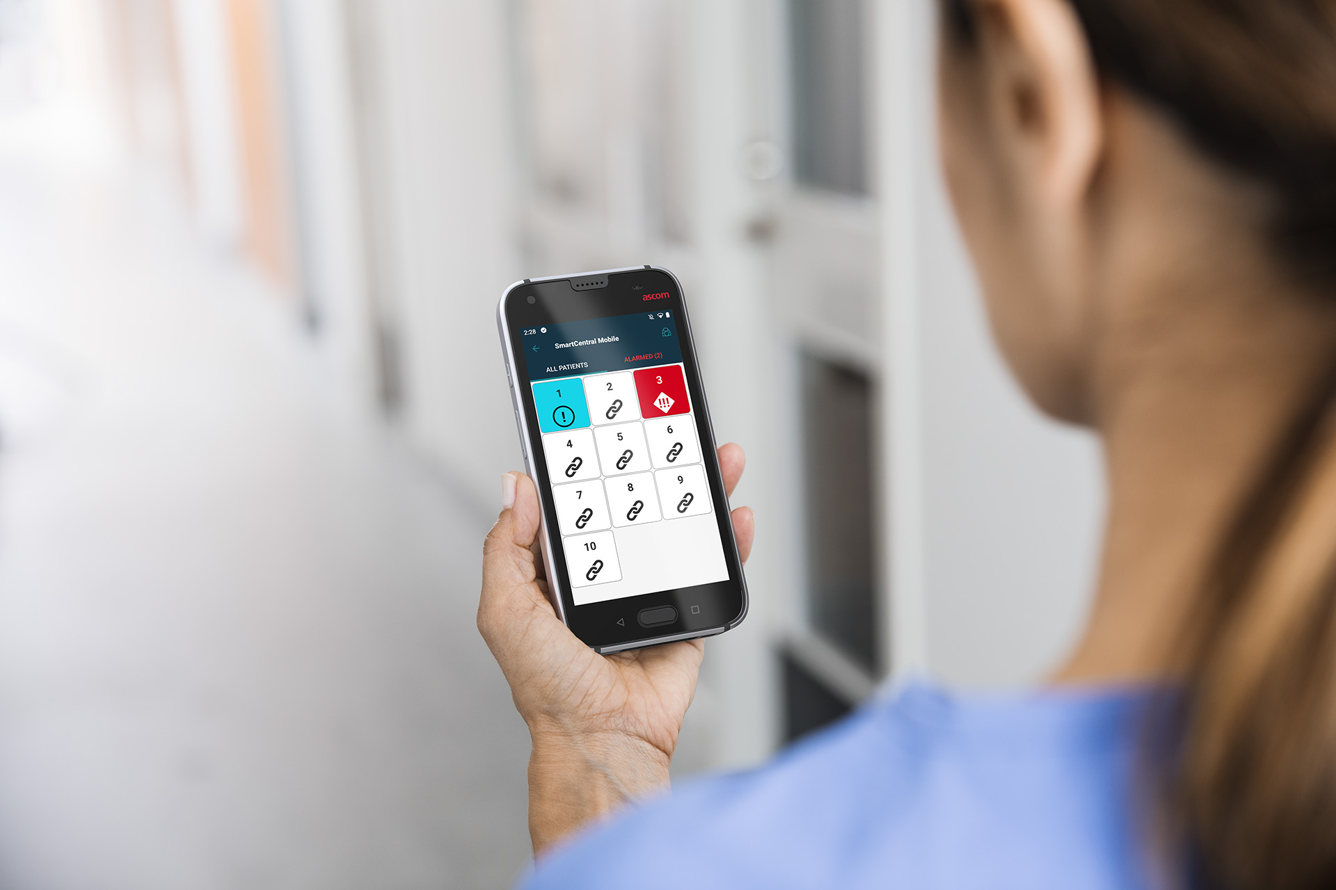 nurse looking at a myco 3 phone with alarm notification